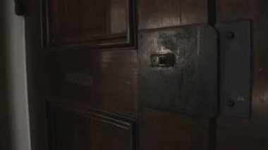 Bologna, İtalya'da eski bir kapı açma bir kadın eli orta çekim.