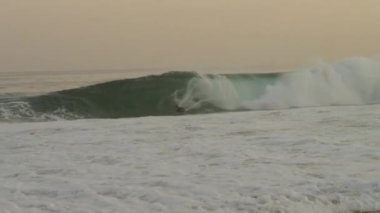 Yavaş çekim, bir sörfçü bir dalga yakalanmış ve sabahın erken saatlerinde Ipanema plajda silerek çekim izleme