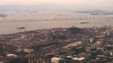 Niteroi Köprüsü ve Rio de Janeiro hava tavası. Rio'nun düzeninin detayları ön planda görünürken, bir yaz Brezilya gökyüzünün renkleri ufukta visibil.
