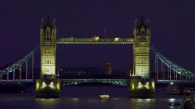 Akşam aydınlatılmış Tower Bridge (Londra) sabit çekim. Arabalar köprüden geçiyor ve altında bir tekne var. 10 Ekim 2011 tarihinde çekildi..