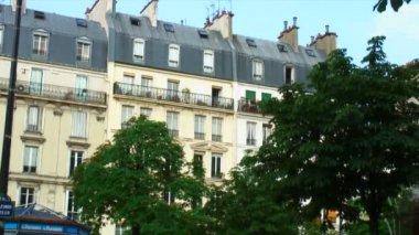 Satır binaların Bruges, Belçika ile yeşil ağaçlar ve ön planda geçenler.