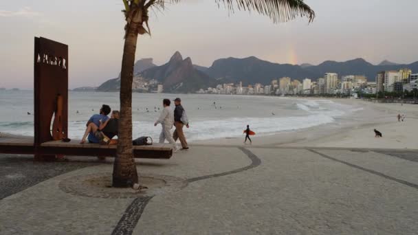 里约热内卢 2013年6月 一对夫妇坐在里约热内卢Ipanema海滩鹅卵石休息区的长椅上 在摄像机靠近时眺望水面 在背景中可以看到海滩 — 图库视频影像