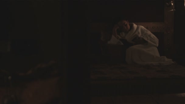 在意大利一家酒店的床上看书的女人 — 图库视频影像