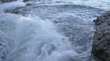 Pürüzlü kayalara çarpan ağır dalgaların yavaş hareketini izleme.