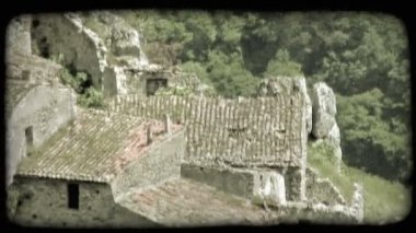 Büyük, basit bir taş binanın büyümüş kalıntılarına bakan yüksek açılı görüntüler. Vintage stilize video klip.