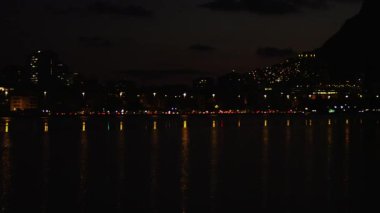 Yavaş, uzun mesafe pan Rio de Janeiro kıyı geceleri gelen su vücut. Şehir ışıkları suda yansıtacak.
