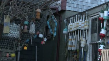 Ağlar, şamandıralar ve kafesleri Rockport, Massachusetts bir yıpranmış balıkçılık kulübede, duvarlarda asılı balıkçılık yavaş pan şamandıralar.