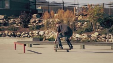 Bir rayüzerinden atlayan patencinin, sonra da 360 kaydırağı yaparken çekilmiş. Patenci rayüzerinde ollies, dengesini geri kazanır, sonra bir bankaya sürmeden önce slayt yok.
