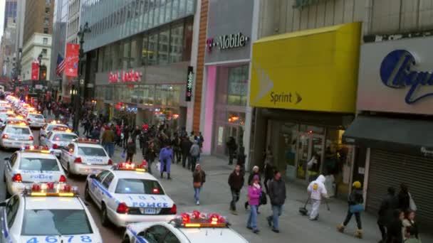 ニューヨーク市で多くのパトカーがライトを点滅させ 歩道を歩いている歩行者のドリーショット 道路の脇に並んでいる — ストック動画