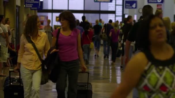 ユタ州ソルトレーク シティー Circa 2012 他の女性が空港で荷物を待つ間 2人の女性が荷物を持ってカメラに向かって歩きます — ストック動画