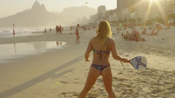 里约热内卢 2013年6月 慢动作 180跟踪拍摄一对夫妇在伊帕内马海滩打网球在黄昏时分在Dois Irmaos和里约公寓的背景 — 图库视频影像