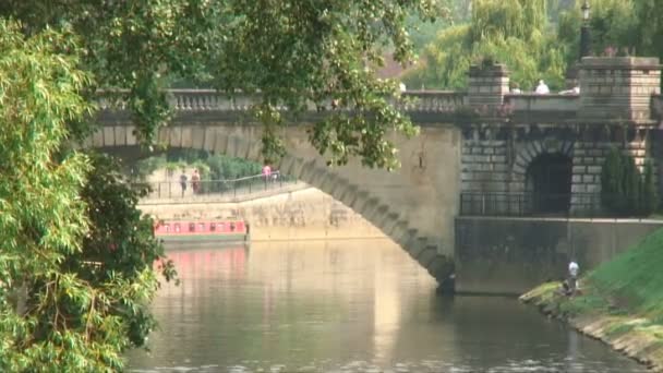 橋付近の川岸に座っている人とお風呂 イギリスのエイボン川のショット — ストック動画