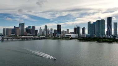 Aerial view of the Miami skyline as boat cruises on the water at Biscayne Bay.
