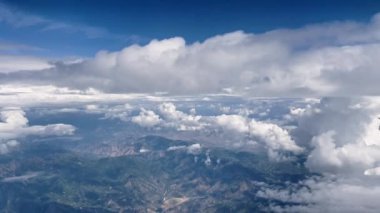 View from airplane above the clouds looking down at Utah and the Wasatch Mountains.