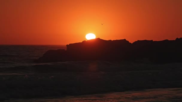日落时分 明亮的橙色天空笼罩着加利福尼亚海滩上的岩石 — 图库视频影像