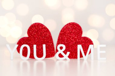 you and me - an inscription of white letters on a light background with bokeh