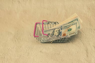 Küçük alışveriş arabasında dolar. Çıplak arkaplan