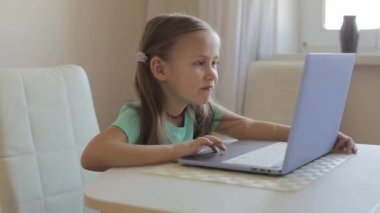 Küçük tatlı kız video oyunu, eğitim ya da oyun oynamak için dizüstü bilgisayar kullanıyor..
