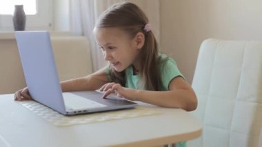 Küçük tatlı kız video oyunu, eğitim ya da oyun oynamak için dizüstü bilgisayar kullanıyor..