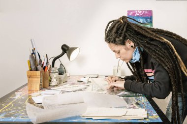 Latin kökenli güzel, genç ve güzel bir Latin sanat yönetmeni kızı. Rastalı ve iyi stili olan. Yapım stüdyosunda, soğan kağıdına bir resim çiziyor..