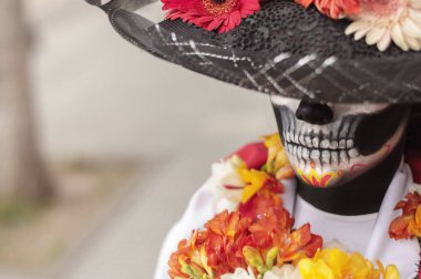 La Calavera Catrina makyajı ve şapkası açık havada gözlerini kapatan bir kadının yüksek açılı görüntüsü..