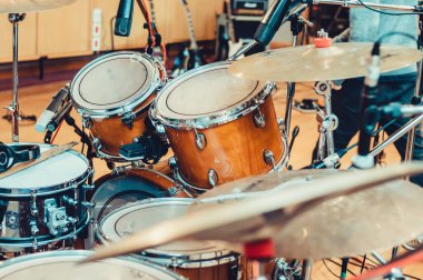 Profesyonel mikrofonları olan güzel maun renkli akustik davullar. Profesyonel prova odasında kayıt yapmaya hazır. Müzik endüstrisi konsepti..