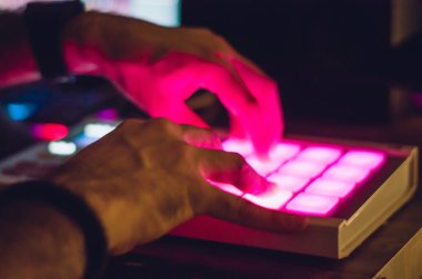Erkek ellerinin bulanık görüntüsü midi kontrolör kullanıyor, kentsel ve elektronik müzik yapıyor, ev stüdyosunda ticari müzik ritmi yaratıyor, müzik endüstrisi konsepti.