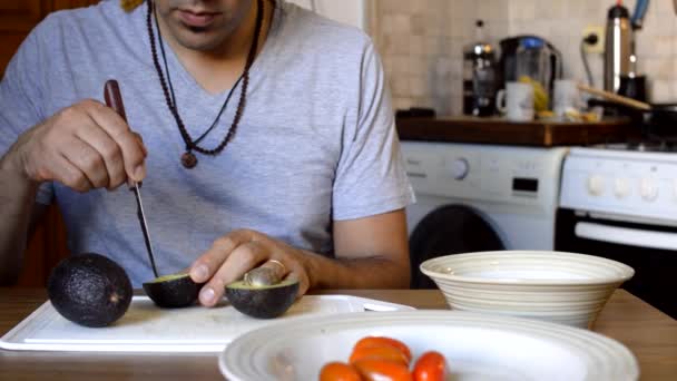 Hombre Caucásico Argentino Cocina Casa Sentado Cortando Aguacate Con Cuchillo — Vídeo de stock