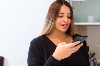 Kafkasyalı genç kadın evde yüksek sesle telefonla konuşuyor, evinde sohbet ederek iletişim kuruyor, yaşam tarzı ve teknoloji kavramı..