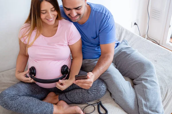 Happy Caucasian Young Pregnant Woman Headphones Tummy Husband Playing Music — ストック写真