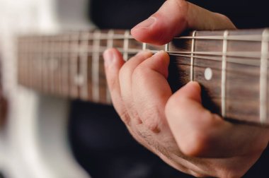 Erkek eli elektro gitarda bükme tekniği uyguluyor, sol ele odaklanıyor..