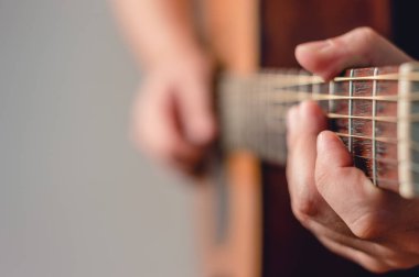 Akustik gitar çalan tanınmayan beyaz adamın profilini kapat, sol ele odaklan, kopyalama alanı, müzik ve eğlence konseptine odaklan.