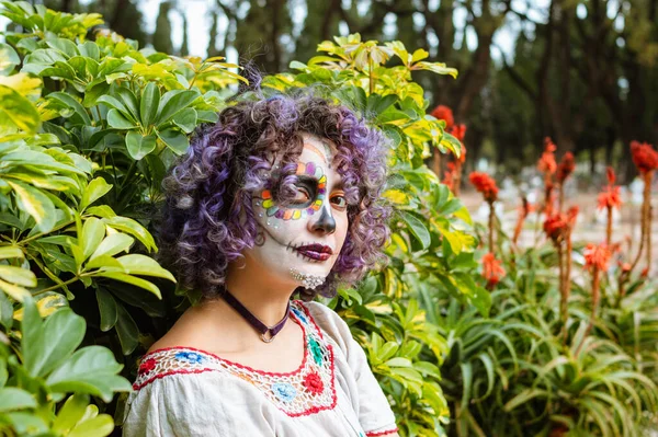 young latin caucasian woman with Catrina makeup sitting outdoors, visiting her dead relatives in the cemetery, day of the dead concept, copy space.