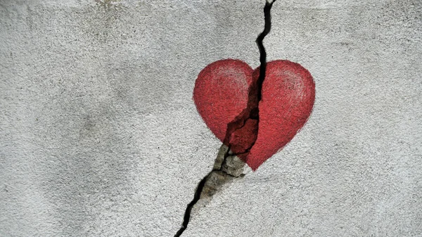 drawing of a heart on a very old cracked rough wall