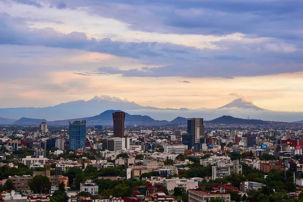 Mexico City 'nin panoramik fotoğrafı, arka planda Iztlacihuatl volkanları ve popocatepetl manzaralı bulutlu bir öğleden sonra.