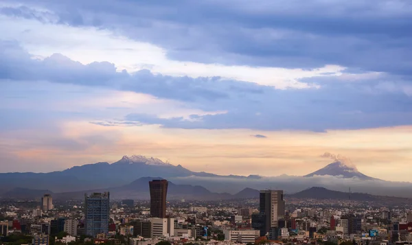 Mexico City 'nin panoramik fotoğrafı, arka planda Iztlacihuatl volkanları ve popocatepetl manzaralı bulutlu bir öğleden sonra.