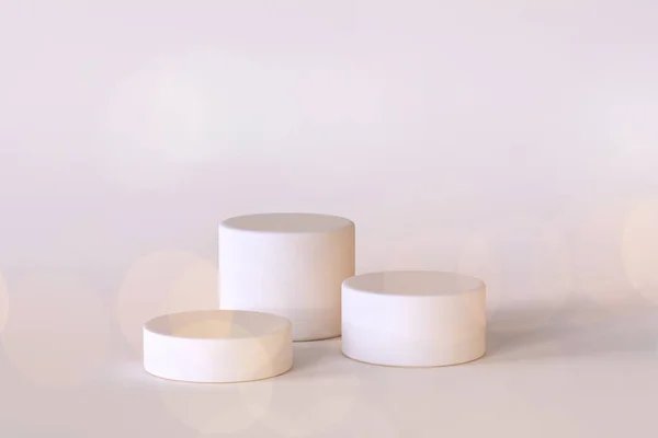 Üç beyaz podyumun 3D görüntüsü. Kozmetik veya ürün sunum şablonu için minimalist sahne