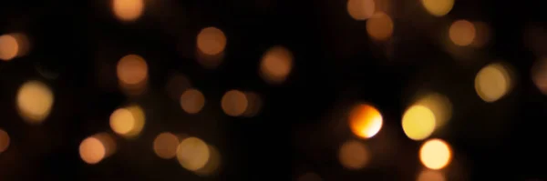 Lumières bokeh déconcentrées sur fond noir, une bannière abstraite naturellement floue — Photo