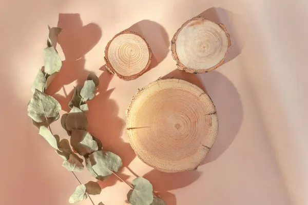 Kozmetik için üç ahşap podyum ya da bej arka planda ürün sunumu. Düz yatış, üst görünüm