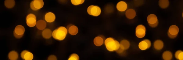 Defokussierte Bokeh-Lichter auf schwarzem Hintergrund, ein abstraktes, natürlich verschwommenes Banner — Stockfoto