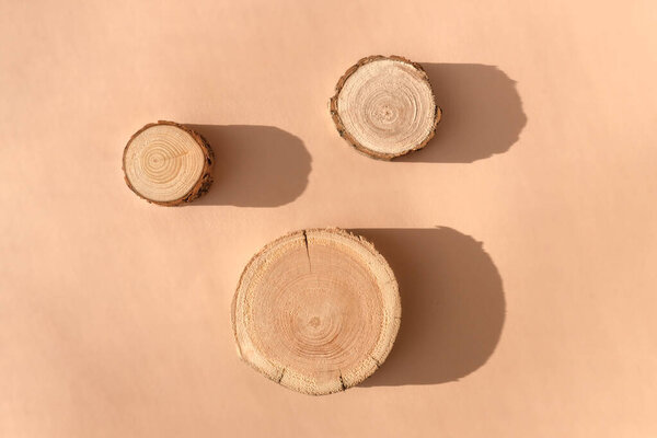 Three woodcut disks lying on a trendy beige background 