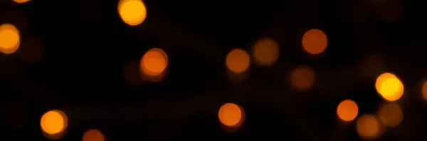 Defokussierte Bokeh-Lichter auf schwarzem Hintergrund, ein abstraktes, natürlich verschwommenes Banner — Stockfoto