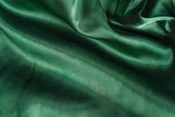 エレガントな滑らかな緑のシルクやサテンの折り目を閉じます。布の質感の背景。要旨壁紙 — ストック写真