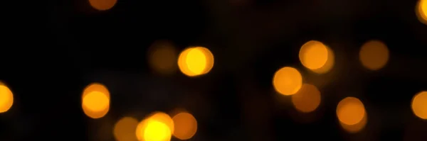 Defokussierte Bokeh-Lichter auf schwarzem Hintergrund, ein abstraktes, natürlich verschwommenes Banner — Stockfoto