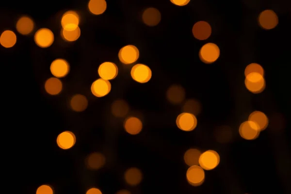 Defokussierte Bokeh-Lichter auf schwarzem Hintergrund, ein abstrakter, natürlich verschwommener Hintergrund — Stockfoto