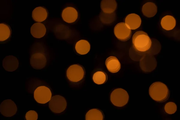 Lumières bokeh déconcentrées sur fond noir, une toile de fond abstraite naturellement floue — Photo