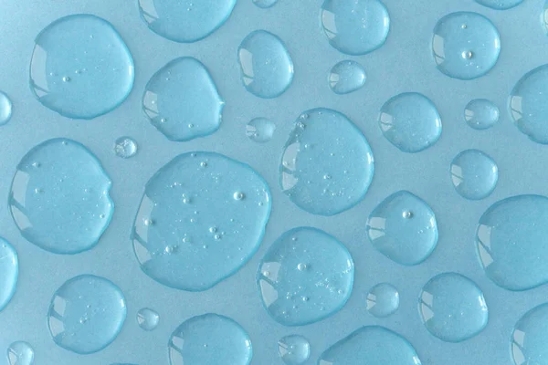 Dosis de gel o suero de color azul sobre fondo monocromo. Patrón de telón de fondo abstracto — Foto de Stock