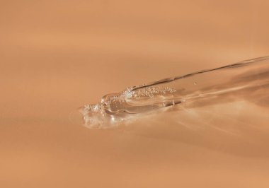 Moda bej arka planında sıvı hyaluronik asit olan bir boru. Kozmetik ve sağlık konsepti yakın plan