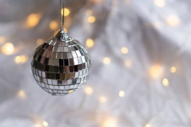 Sarı çelenk desenli yumuşak bir arka planda gümüş disko topu. Hafif xmas kompozisyonu, Noel teması