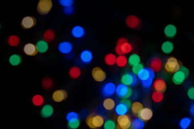 Siyah arkaplanda odaksız renkli bokeh ışıkları, soyut, doğal olarak bulanık bir arkaplan